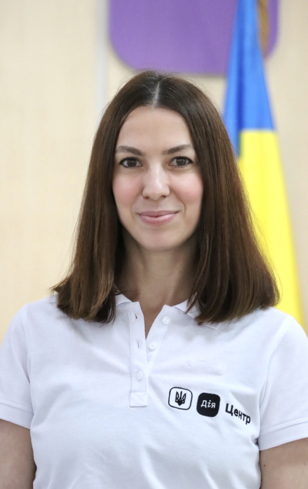 Жінка з коротким темним волоссям у футболці, привітно посміхається.